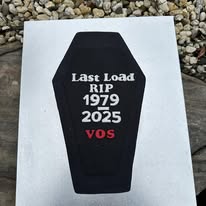 Black coffin shaped cake reading Last Load RIP 1979-2025 VOS retirement cake